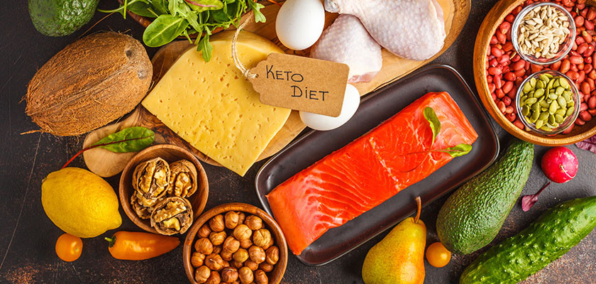 Keto diet concept. Balanced low-carb food background. Vegetables, fish, meat, cheese, nuts on a dark background.